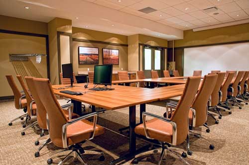 Sala de reuniões com mesas e cadeiras na cor marrom
