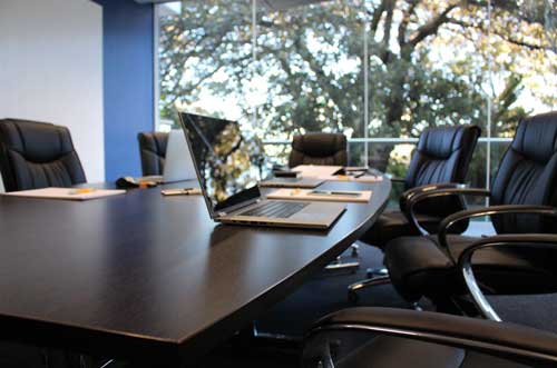 Sala de Reuniões com cadeiras e mesa no tom cinza e preto.